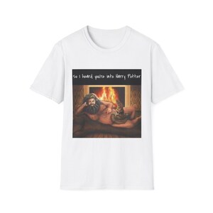 May include: White t-shirt featuring a graphic of a man with a beard and a sorting hat in front of a fireplace. The text "So I heard you're into Harry Potter" is above the graphic.