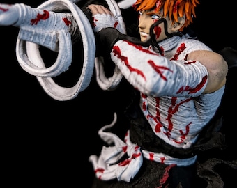 May include: A detailed anime-style action figure featuring a character with spiky orange hair, wearing a white bandage-wrapped torso and black pants. The figure is covered in red blood-like paint splatters and holds a long, white, coiled weapon.
