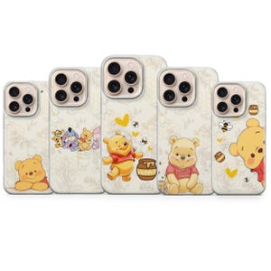 Può includere: Cinque cover trasparenti per smartphone con i personaggi di Winnie the Pooh. I disegni includono Pooh, Pimpi, Tigro e Ih-Oh, insieme a vasetti di miele con la scritta HUNNY, api e cuori gialli su uno sfondo con un leggero motivo a linee.