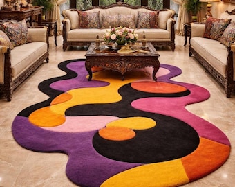May include: A colorful, abstract area rug with a unique, flowing shape. The rug features a mix of vibrant colors, including purple, black, orange, yellow, and pink. The rug is placed in a luxurious living room setting with ornate furniture.