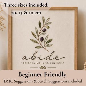 Op de afbeelding: Geborduurde wandkunst in een houten lijst. Het kunstwerk toont een olijftak met groene bladeren en paarse olijven, en het woord "abide" in sierlijke letters. Tekst omvat "ABIDE IN ME, AND I IN YOU." en "Beginner Friendly." Drie maten zijn inbegrepen: 20, 15 en 10 cm.