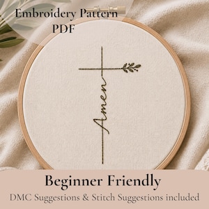 Pode incluir: Um bastidor de bordado com um tecido bege com um desenho de cruz com a palavra "Amém" costurada com linha escura. O desenho inclui um pequeno detalhe de folha. O texto na parte superior diz "Embroidery Pattern PDF" e na parte inferior "Beginner Friendly".