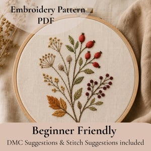 Pode incluir: Embroidery Pattern PDF Beginner Friendly DMC Suggestions & Stitch Suggestions included. Um bastidor de bordado circular de madeira emoldura um tecido cor de creme com um design botânico de bagas vermelhas, folhas verdes e flores silvestres amarelas.