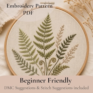 Op de afbeelding: Een borduurpatroon PDF met een ronde houten borduurring met een botanisch ontwerp van diverse varenbladeren, geborduurd in tinten groen en beige op gebroken wit textiel. De tekst luidt Embroidery Pattern PDF, Beginner Friendly.