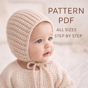 May include: A baby wearing a cream-colored knitted bonnet and sweater. The bonnet ties under the chin with a matching knitted tie. The image includes the text "PATTERN PDF ALL SIZES STEP BY STEP".