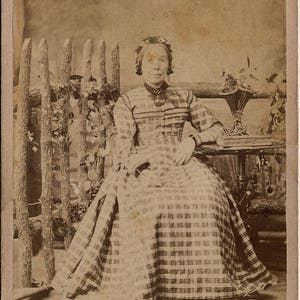 Vintage English CDV of an Older Woman Seated Wearing a Big Plaid Gown  in a Faux Studio Rustic Country Scene