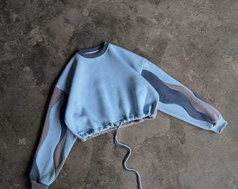 Übergroßes himmelblaues Sweatshirt mit gewellten Ärmeln und verstellbarem Saum