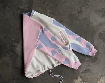 Übergroßes, cremefarbenes Sweatshirt mit gewellten Ärmeln mit Herzmuster und blauem Rand