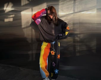 Übergroßes schwarzes Lounge-Set mit gewellten Regenbogenstreifen und Blumenapplikationen