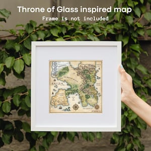 May include: A framed map inspired by Throne of Glass, featuring a detailed illustration of a fantasy world. The map is in a white frame, with text that reads "Throne of Glass inspired map" and "Frame is not included". The map includes the text "CERILEA".