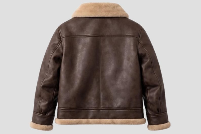 May include: A brown leather jacket with a beige shearling collar and trim. The jacket has a classic aviator style with a tailored fit, featuring a smooth, textured finish and a warm, inviting aesthetic.