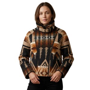 May include: A cropped jacket featuring a high collar with a buckle strap closure. The garment displays a geometric pattern in shades of black, tan, and brown, with an asymmetrical front zipper closure and long sleeves.