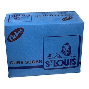 May include: A blue box of St. Louis Cube Sugar. The box features the brand name, a lion emblem, and the words "Cube Sugar". The box also has the word "Cubes" in a red oval.