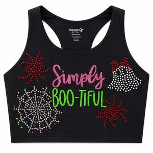 May include: A black racerback crop top featuring the text "Simply BOO-TIFUL" in pink and green glitter. The design includes rhinestone-embellished spider webs and spiders in red, white, and multicolored accents. The interior label reads Old Navy Active.