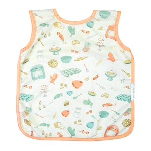 May include: A white sleeveless bib with a peach trim. The bib has a pattern of various baking-themed illustrations, including cakes, ovens, and kitchen utensils. The text "Village Baby" is printed on the right side of the bib.
