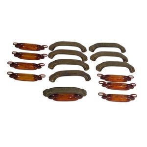 May include: A collection of vintage cabinet hardware, including bronze-toned arched handles and amber-colored oval pulls. The hardware is arranged on a white background, showcasing the variety of shapes and finishes.