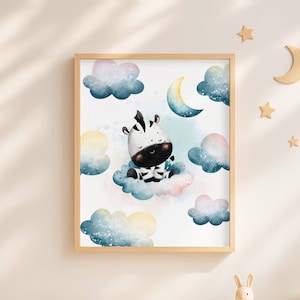 Op de afbeelding: Een ingelijste kunstdruk met een aquarelillustratie van een kleine zebra die op een blauwe wolk zit. De scène bevat een halve maan en verschillende zachtgekleurde wolken in tinten blauw, roze en geel tegen een witte achtergrond.