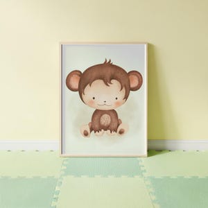May include: A framed watercolor print of a cartoon monkey. The monkey is brown with a light tan face and ears. It is sitting with its legs crossed and has a sweet expression. The background is a soft green.