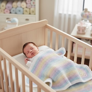 Könnte beinhalten: Ein schlafendes Baby in einem hellen Holzbettchen, bedeckt mit einer gehäkelten Decke in Pastell-Regenbogenfarben. Das Bettchen befindet sich in einem hellen Raum mit einer Kommode und einem Fenster im Hintergrund.