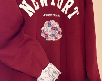 ¡Encaje, conchas de retazos y mucho rojo! Esta sudadera de cuello redondo es el complemento perfecto para tu guardarropa de verano.