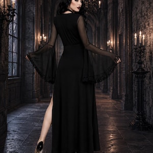 May include: A floor-length black dress featuring long, sheer bell sleeves with lace trim at the cuffs. The garment has a fitted bodice, a high-waisted skirt with a side slit, and a solid black fabric construction throughout the main body.