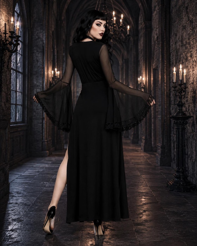 May include: A floor-length black dress featuring long, sheer bell sleeves with lace trim at the cuffs. The garment has a fitted bodice, a high-waisted skirt with a side slit, and a solid black fabric construction throughout the main body.