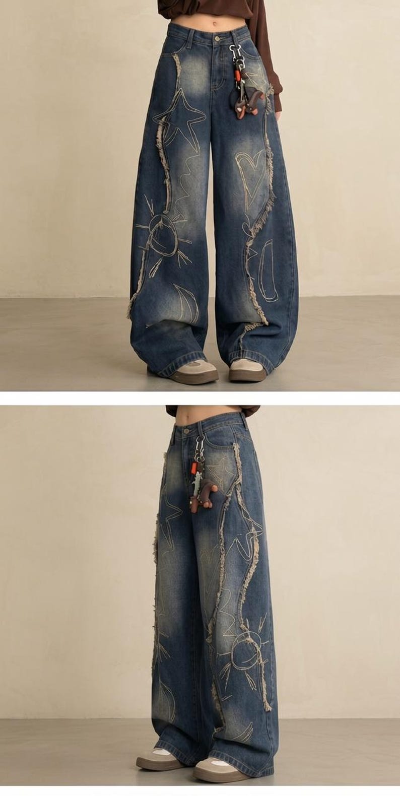 May include: Wide-leg, distressed denim jeans in a medium wash. The jeans feature decorative stitching and graphic designs of stars, suns, and hearts. Frayed edges and a keychain add detail to the casual, yet stylish, design.