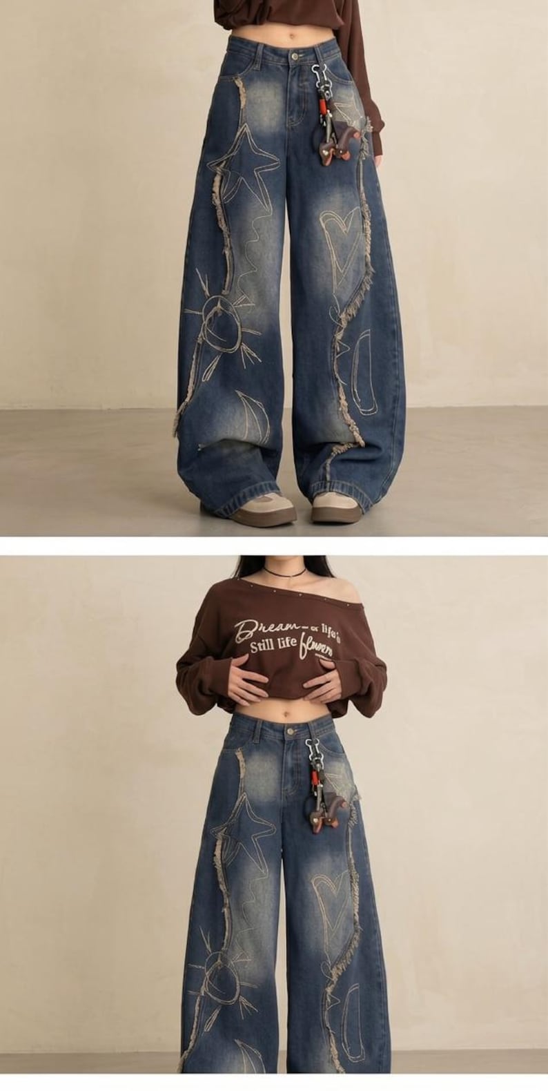 May include: Wide-leg, distressed denim jeans with embroidered star, sun, and heart designs. The jeans have a faded wash and frayed edges. A brown off-the-shoulder sweatshirt with the text "Dream of life, Still life flower" is also visible.
