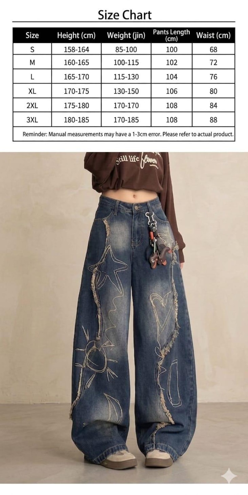 May include: Blue denim wide-leg jeans with white embroidered star and sun designs. The jeans have distressed detailing and a high waist. A size chart is visible, with measurements in centimeters, including height, weight, pants length, and waist.