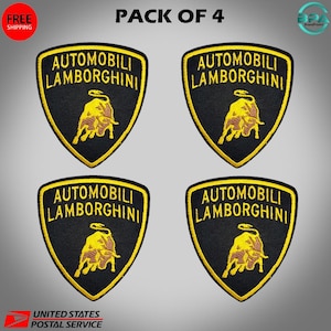 May include: Four black and yellow Lamborghini patches. Each patch features the text "AUTOMOBILI LAMBORGHINI" and a yellow bull emblem. The patches are shield-shaped and have a yellow border. The image includes "PACK OF 4" text.