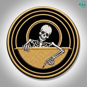 May include: A circular embroidered patch featuring a white skeleton torso and skull emerging from behind a gold-colored semi-circle. The design is framed by concentric black and gold rings, creating a bold, high-contrast graphic emblem.
