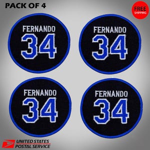 May include: Four circular patches with the name "FERNANDO" above the number "34" in blue and white. The patches are black with a blue border. The text "PACK OF 4" is at the top.
