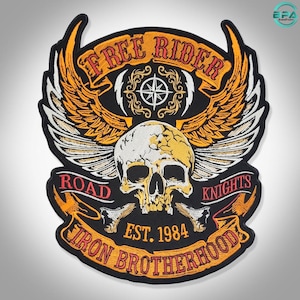 May include: A black embroidered patch featuring a central white skull with orange and white wings. The text reads FREE RIDER at the top, ROAD KNIGHTS in the middle, and IRON BROTHERHOOD at the bottom, with EST. 1984 centered below the skull.