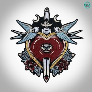May include: An embroidered patch featuring a central red heart with a single eye in the middle, pierced by a silver dagger. The design includes two light blue swallows, two crescent moons, and dark red flowers, all outlined in black thread.
