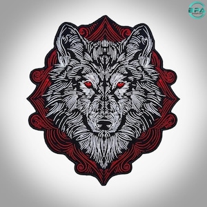 May include: An embroidered patch featuring a detailed wolf head with white fur and piercing red eyes. The wolf is centered against a dark red, ornate, geometric frame with swirling line patterns that create a sharp, pointed, star-like border.