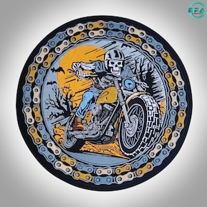 May include: A circular embroidered patch featuring a skeleton riding a motorcycle against a yellow sun and dark landscape. The border is designed as a continuous metal motorcycle chain in alternating silver and gold tones, framing the graphic.
