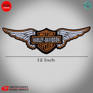 May include: An embroidered Harley-Davidson patch featuring a central shield with orange and black text reading MOTOR HARLEY-DAVIDSON CYCLES, flanked by white and orange wings. The patch is labeled as 12 inches in width below the design.