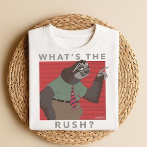 May include: White t-shirt featuring a cartoon sloth character from Zootopia. The sloth is wearing a green shirt and a red and blue striped tie. The text "WHAT'S THE RUSH?" is printed above and below the sloth illustration.