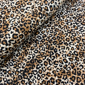 May include: Brown, black, and white leopard print fabric. The fabric has a soft, textured feel.