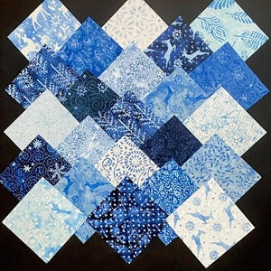 May include: A collection of 20 blue and white fabric squares with various patterns, including snowflakes, reindeer, and floral designs. The squares are arranged in a diamond shape on a black background.