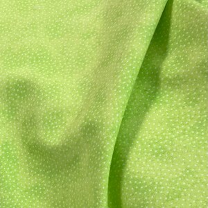 May include: A close-up of a green fabric with a white polka dot pattern. The fabric is folded in half, showing the texture and pattern.