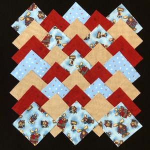 May include: A collection of 18 fabric squares in a variety of patterns and colours, including blue, red, and tan. The squares are arranged in a chevron pattern, creating a visually appealing design. The fabric squares feature a repeating pattern of moose and houses.