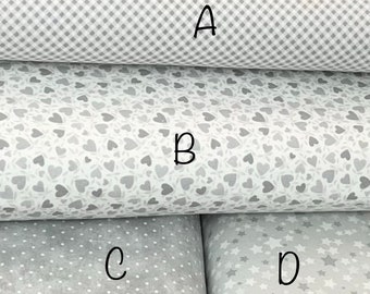 May include: Four different fabric swatches in shades of gray. The top swatch has a white and gray gingham pattern labeled "A". The second swatch has a white background with a gray heart pattern labeled "B". The third swatch has a white background with a gray polka dot pattern labeled "C". The bottom swatch has a white background with a gray star pattern labeled "D".