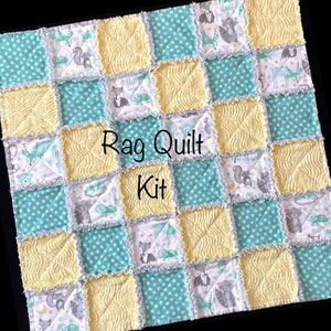 May include: A rag quilt kit featuring a woodland animal print in shades of blue, yellow, and white. The kit includes pre-cut fabric squares and instructions for creating a baby quilt.