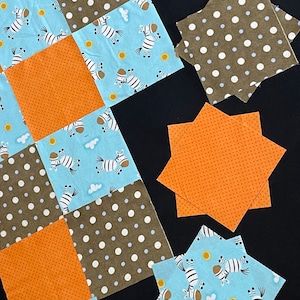 May include: A patchwork quilt with a variety of fabrics, including blue with white zebra print, brown with white polka dots, and orange with white polka dots. The quilt is made up of squares and star shapes.