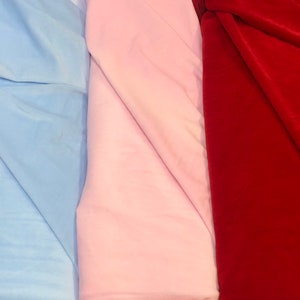 May include: Three fabric swatches, one light blue, one pink, and one red.