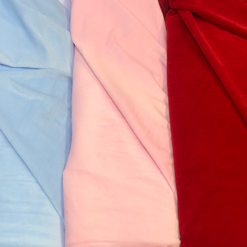 May include: Three fabric swatches, one light blue, one pink, and one red.