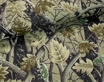 May include: Camouflage fabric with a pattern of brown, green and tan leaves and branches.