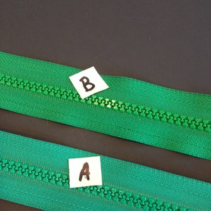 May include: Two green zipper tapes with a white label on each. The label on the top tape says "B" and the label on the bottom tape says "A".