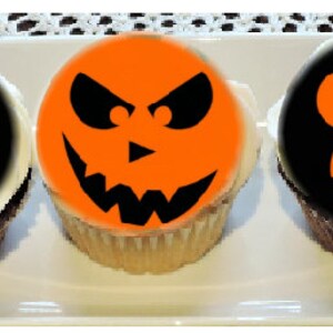 May include: Three Halloween cupcakes with orange and black frosting. The cupcakes are decorated with different jack-o'-lantern faces.